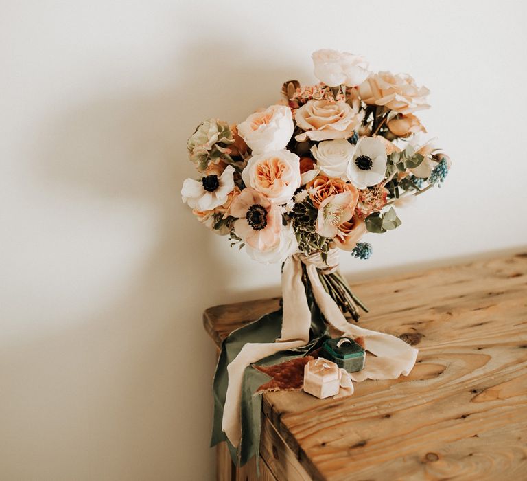 Mixed pastel wedding bouquet with roses tied with pink and green ribbon