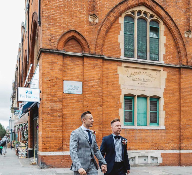 Grooms walk through Chelsea with one another on their wedding day