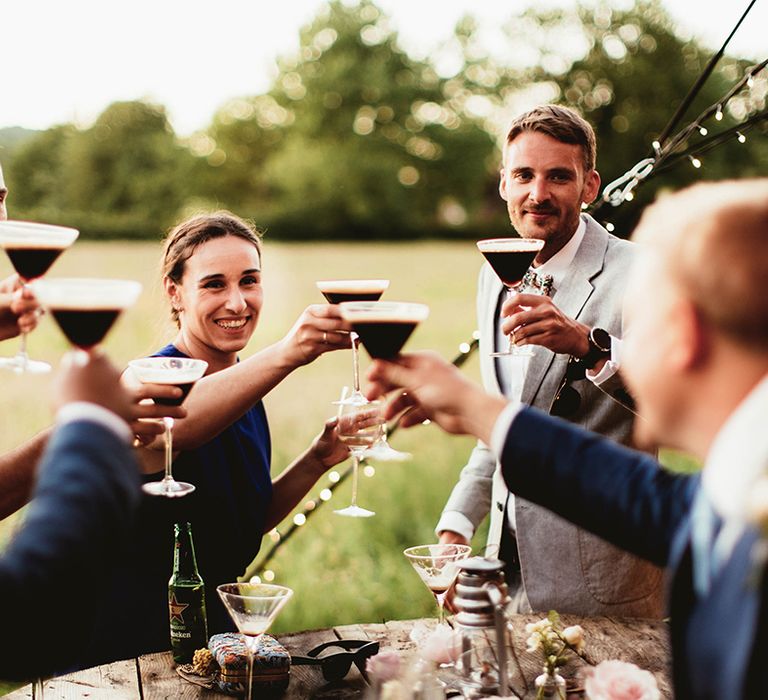 Wedding guests lift their glasses of espresso martinis