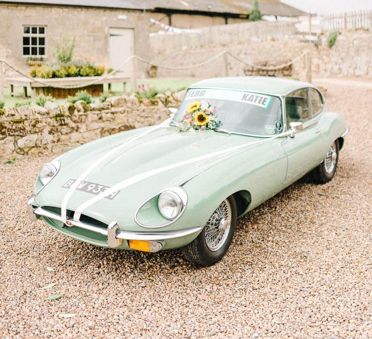 Mint green vintage car for wedding with sunflower decorations and white ribbon