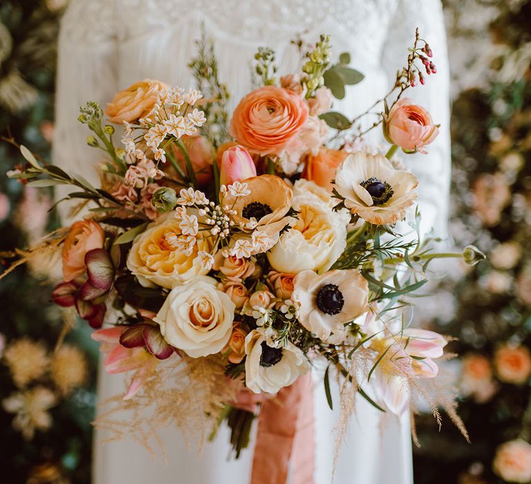 blush peach and pink romantic wedding bouquet with ranunculus, roses and anemones