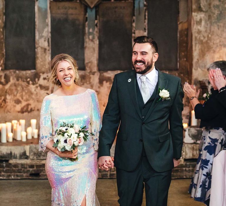 Bride wears iridescent wedding dress with short bell sleeves and rounded neckline