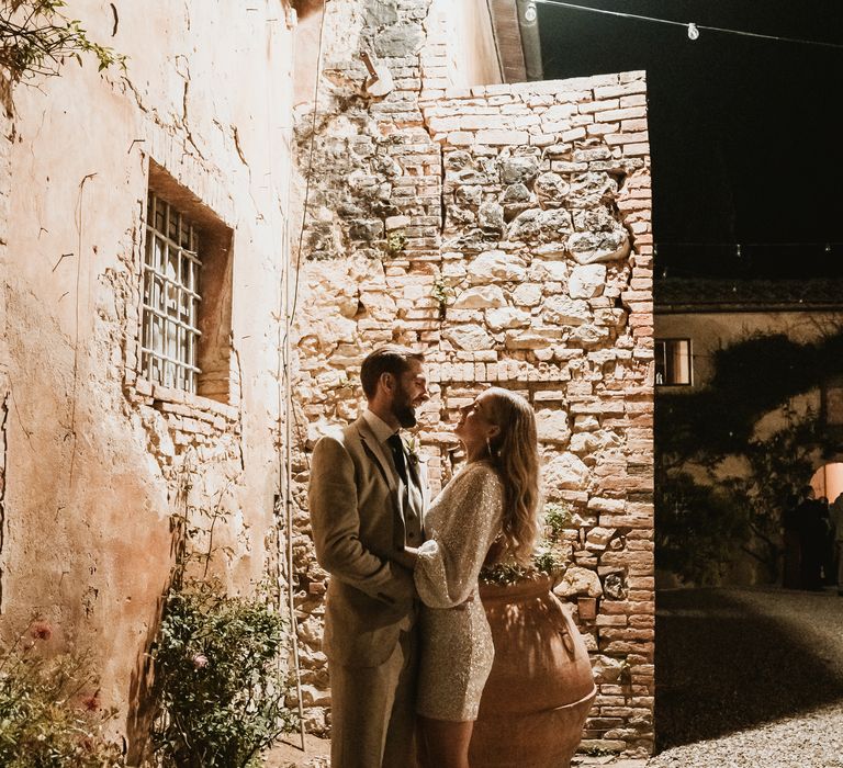 Bride wears short silver sparkling BHLDN dress for reception party 