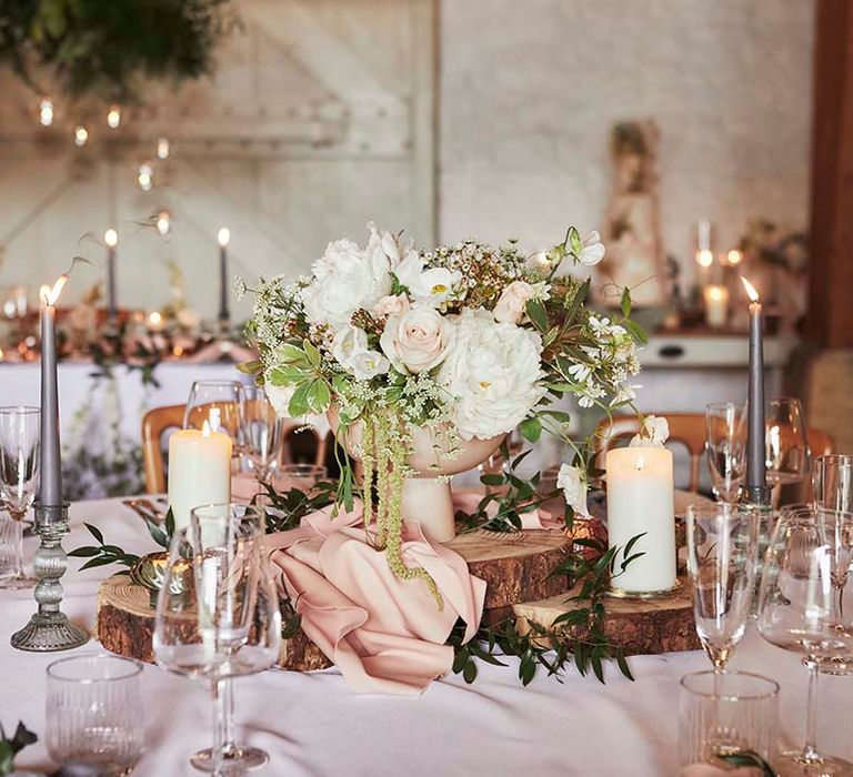 Rustic luxe wedding table centrepiece with pink fabric, rustic tree slice and romantic florals 