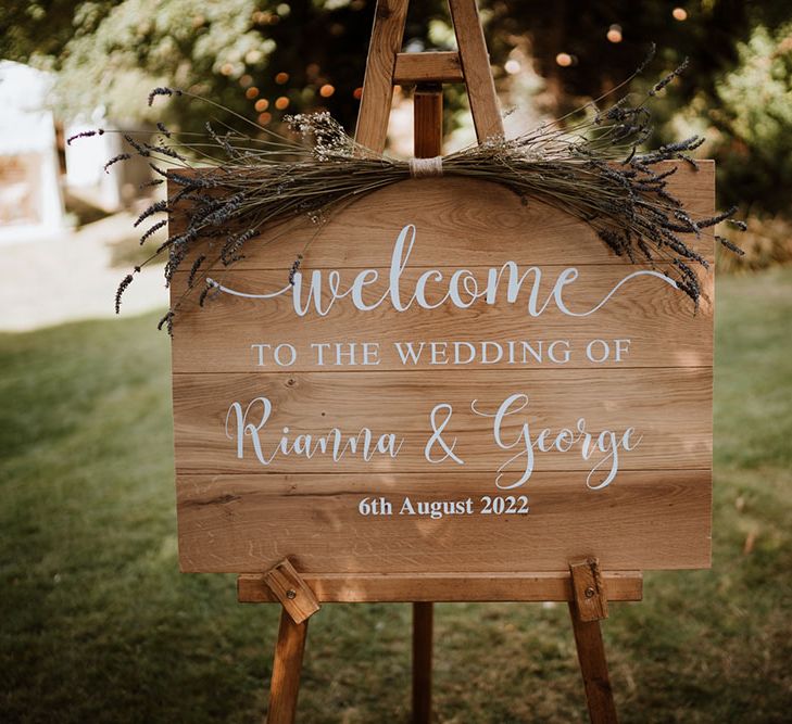 Wooden 'Welcome' sign finished with white writing and lavender decor tied to top 