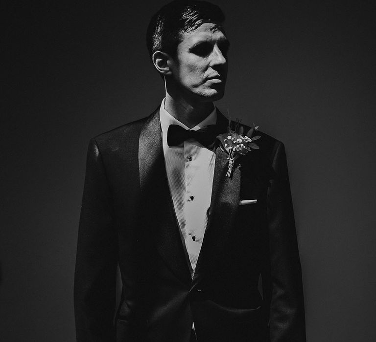 Groom wears black tie complete with pampas grass buttonhole 