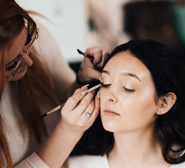 Bride wears natural styled makeup and her dark hair pulled behind her ears