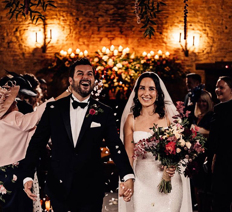 Bride and groom can't stop beaming as they walk back down the aisle to confetti 