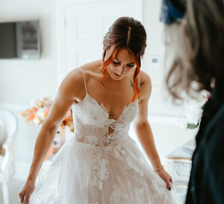 Bride wears Madi Lane bridal wedding dress with sheer lace styling and spaghetti straps 