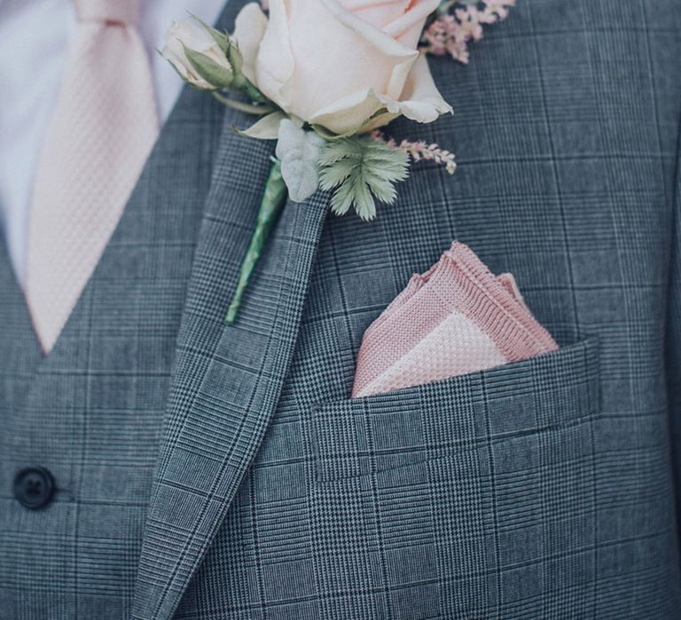 All pink groom accessories with a pink tie, pocket square, and rose buttonhole with grey three piece suit 