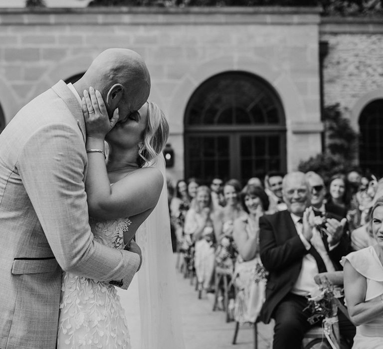 The bride and groom share their first kiss as a married couple after their outdoor civil wedding ceremony at Middleton Lodge Estate wedding venue