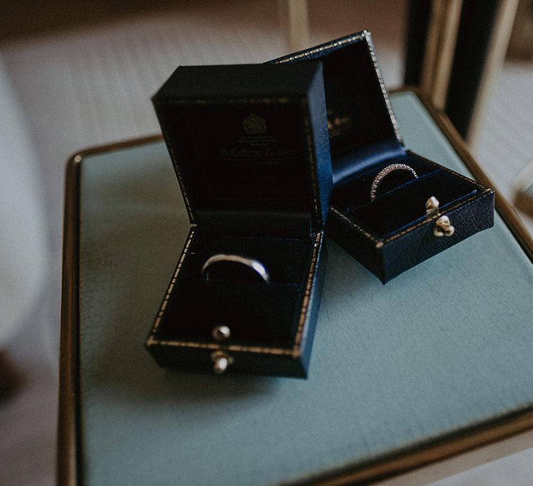 Dark blue jewellery boxes with plain silver wedding band and diamond wedding band for the bride and groom 