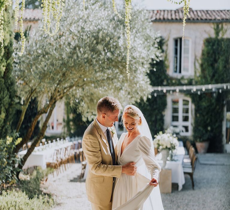 Château de Malliac French wedding venue with bride in a floaty destination wedding dress and groom in a light coloured suit