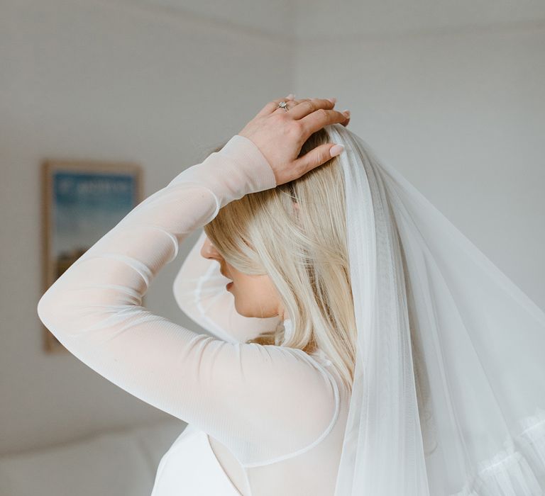 Bride puts on her wedding veil for the day 