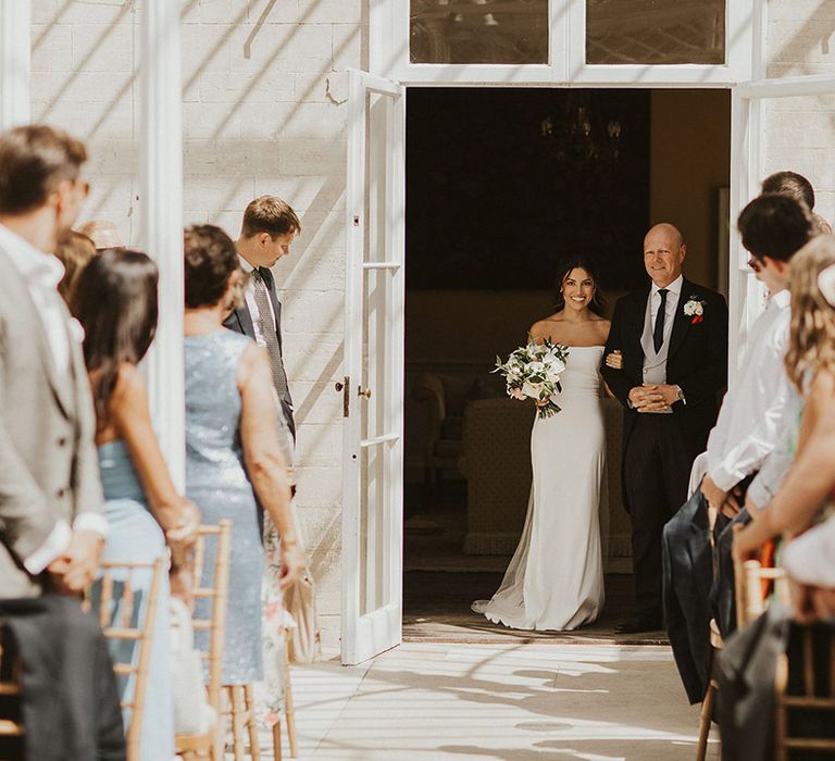 Bride in simple flattering Halfpenny London wedding dress being walked down the aisle by the father of the bride | Steph Newton Photography