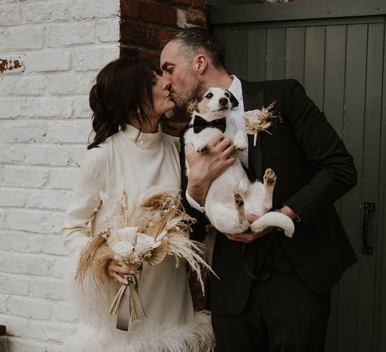 Bride carrying neutral dried wedding flower bouquet with groom and pet dog 