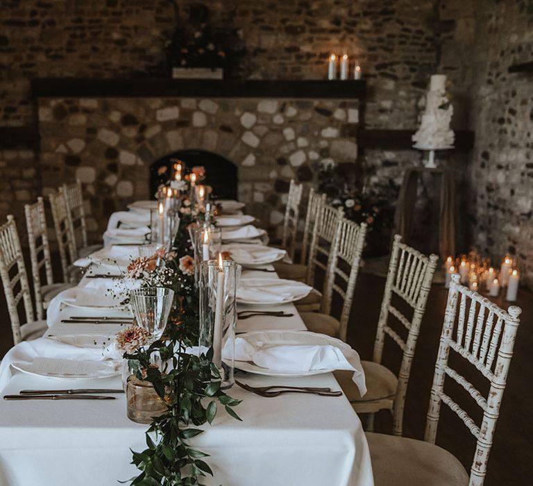 Medieval inspired wedding tablescape with romantic candlelight and floral table runner 