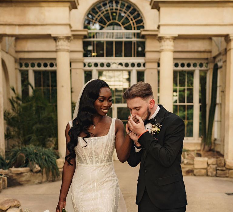 Bride in fitted beaded wedding dress from Rachel Rose Bridal with groom in tuxedo 