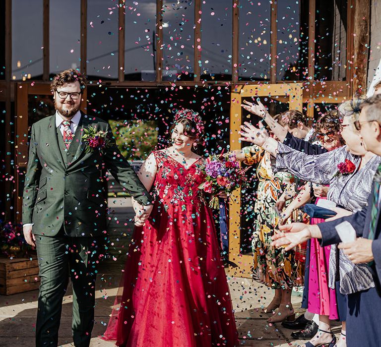 Colourful and bright confetti moment for the bride and groom after their wedding ceremony 