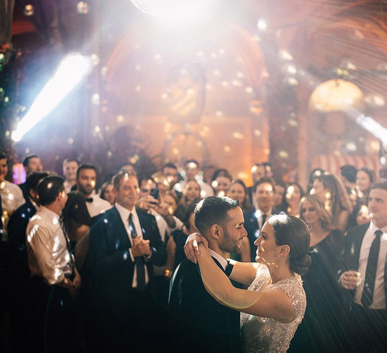 The bride and groom have their first dance with disco balls and lighting 