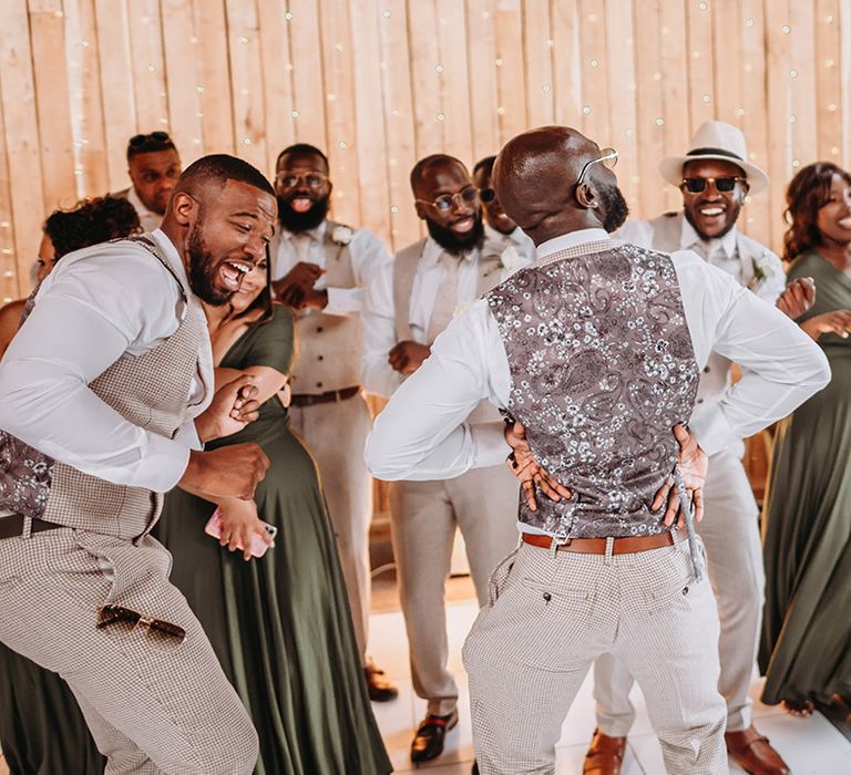 The wedding party dancing together at the wedding reception 