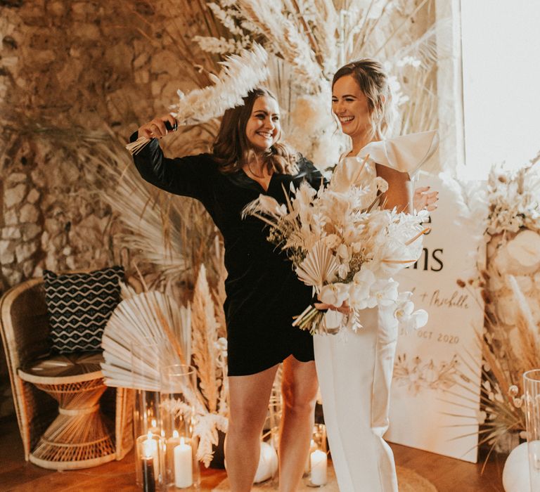 Portrait of the bride in a jumpsuit and the bridesmaid in a black dress 