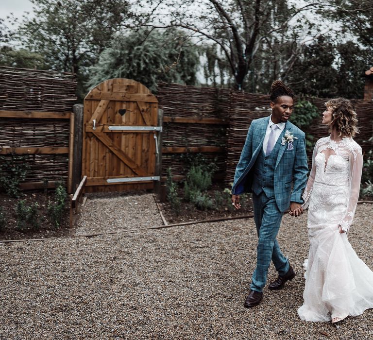 The bride and groom stroll through Sedgewell Barn