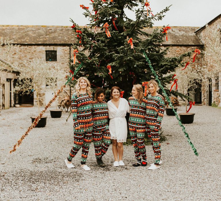 Bride and bridesmaids on the wedding morning in a silk getting ready robe and matching Christmas pyjamas 