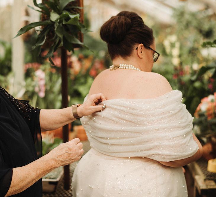 Bride in an off the shoulder wedding dress with pearl embellishment 