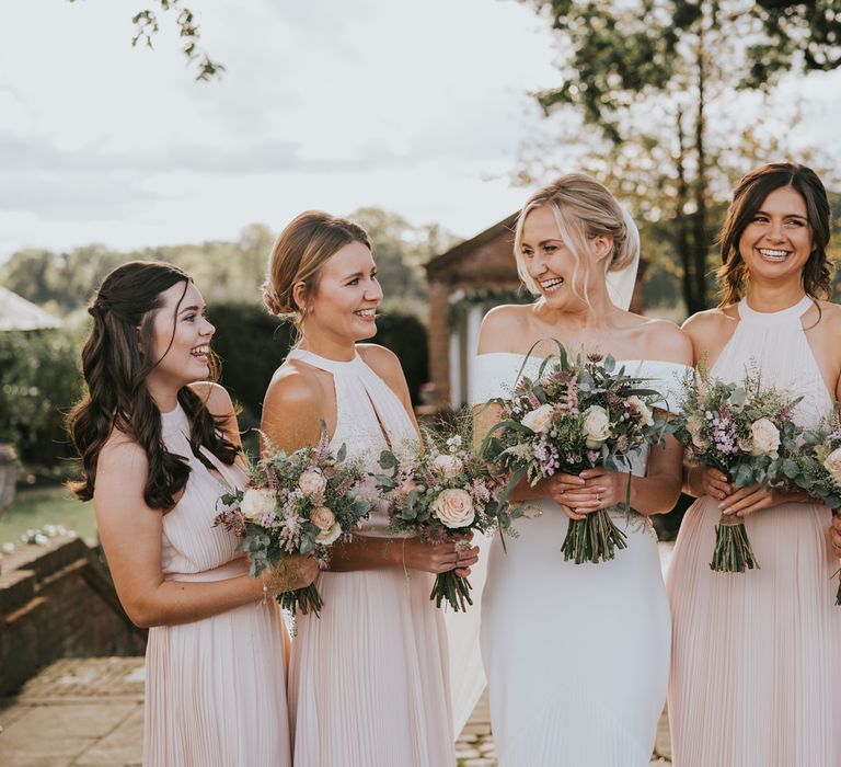 Bride stands with her bridesmaids outdoors