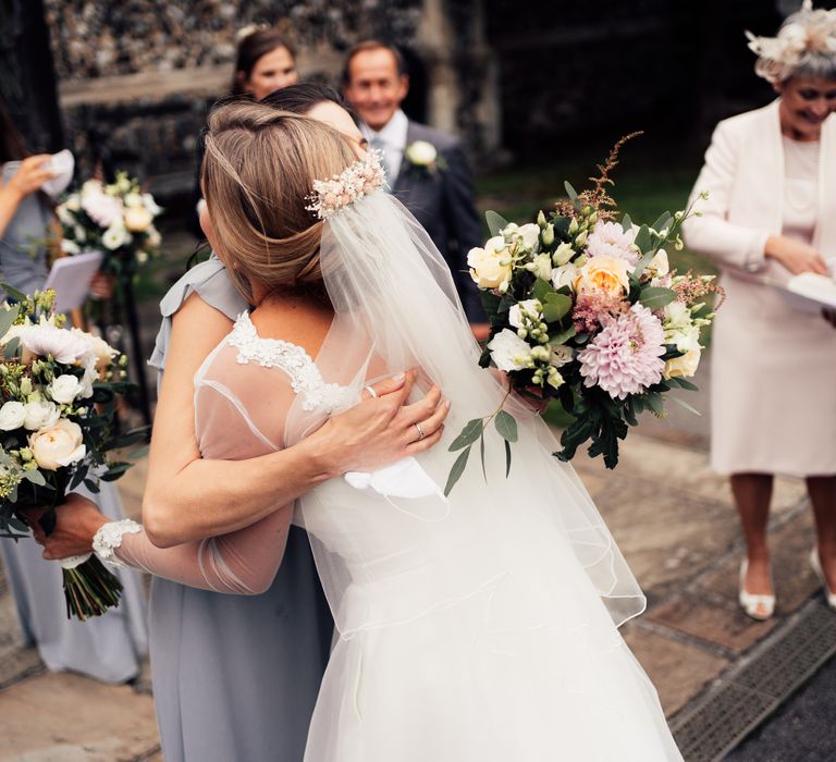 Bride embraces wedding party guest 