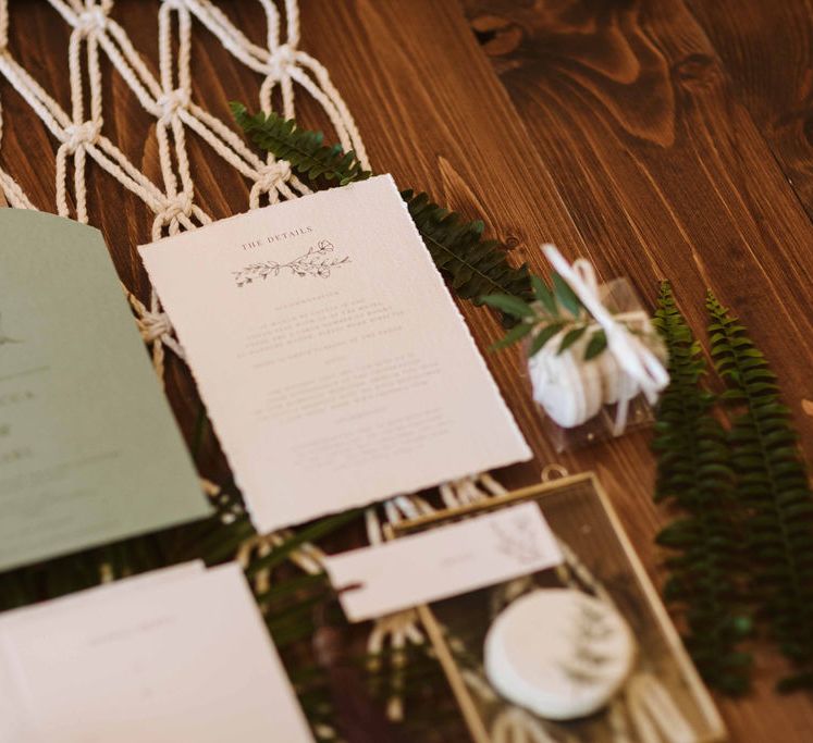 White macrame decor with wedding stationery 