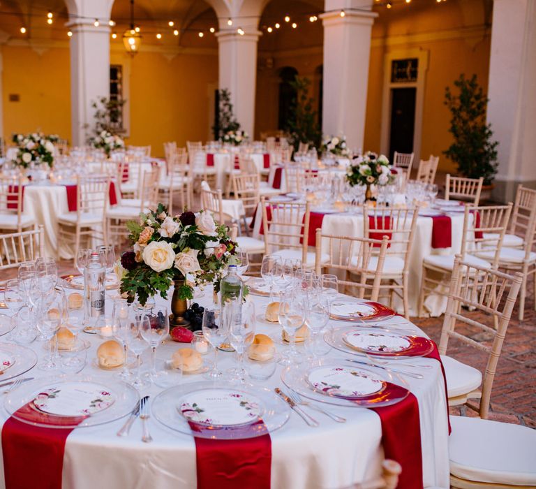 Round wedding tables with red and white decor and floral centrepieces for a wine themed wedding