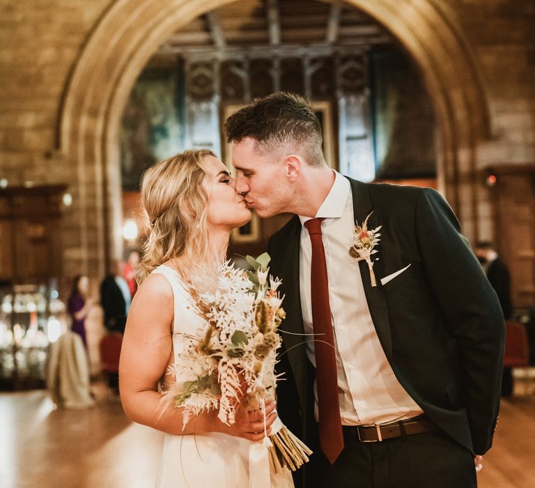 Bride & groom kiss as they leave wedding ceremony