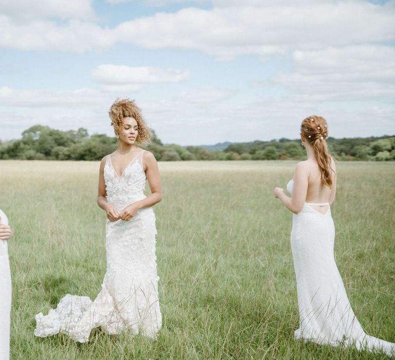 Three brides in the fields at Berwick Lodge wearing boho inspired wedding dresses from Made With Love and Emmy Mae Bridal