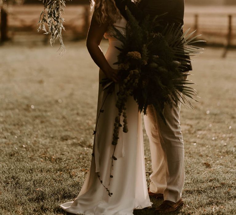 Bride and groom at twilight in a country field 