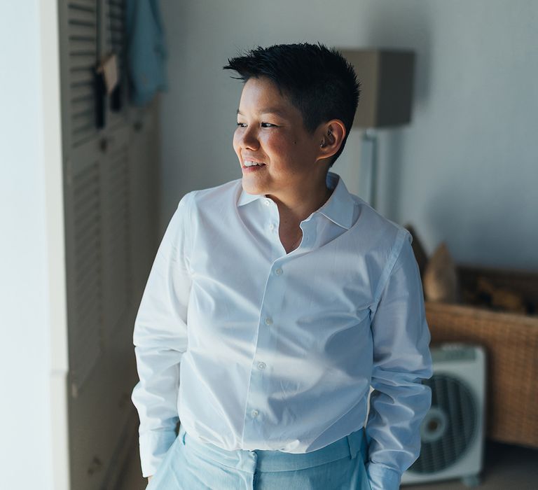 Bride wears pale blue suit and white shirt on her wedding day 