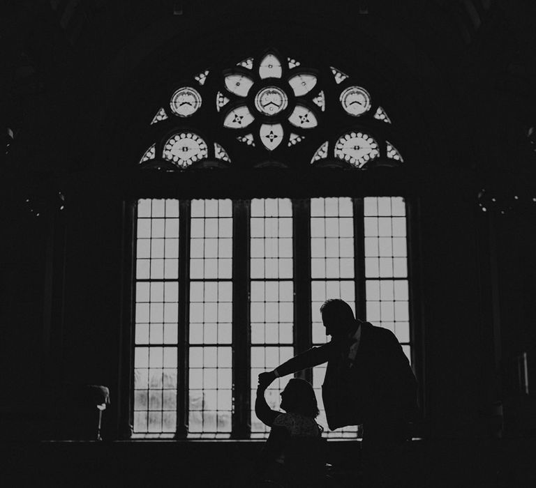 Black and white portrait of a groom twirling his bride in a wheelchair at Dulwich College wedding venue 