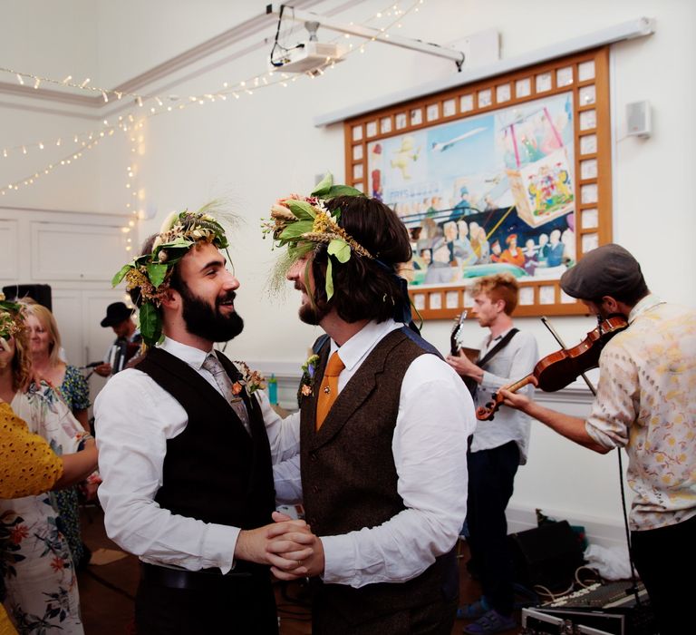 Grooms look at one another as they dance during reception