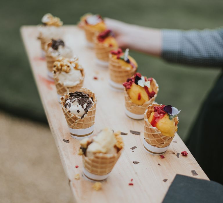 Wooden board with mini ice cream canapés at Tythe Barn wedding with barn wedding flowers