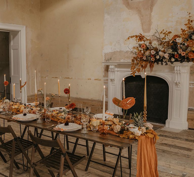 Orange and rustic coloured wedding table decor for autumn wedding at Clerkenwell House with taper candles and anthurium flower stems 