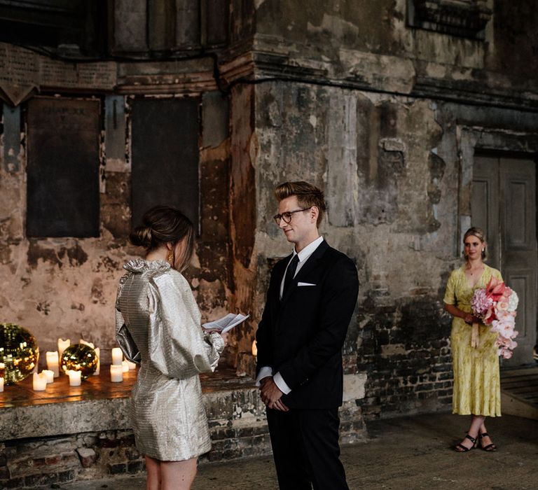 Bride in short gold dress & platforms with Groom in tailored black suit 