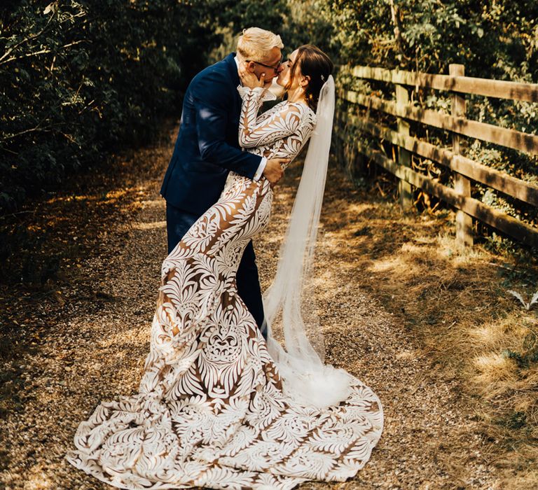 Bride & Groom kiss in forest setting at their unplugged ceremony at Elmley Nature Reserve