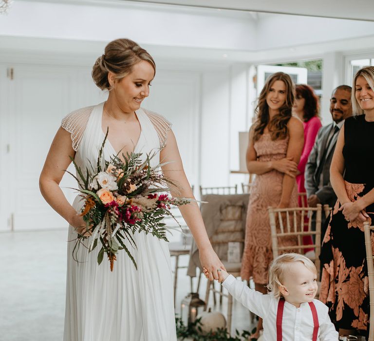 Bride smiles as she walks down the aisle on her wedding day