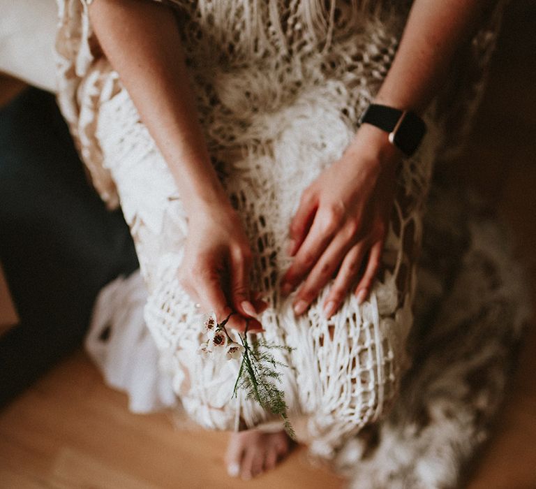 Bride holds green foliage on the morning of her wedding day