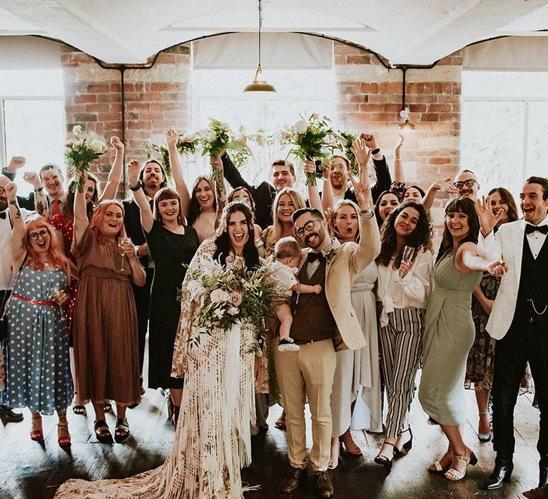 Bride & groom stand with their wedding guests on their wedding day