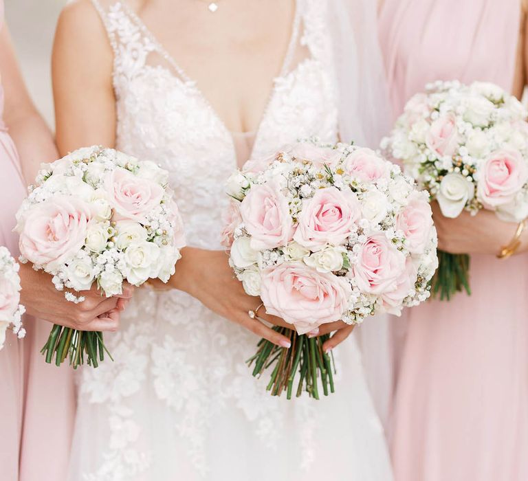 Bride & her bridesmaids hold floral bouquets