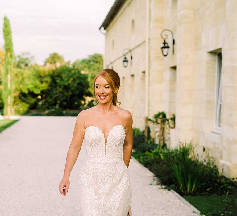 Bride walks through grounds of the chateau on her wedding day