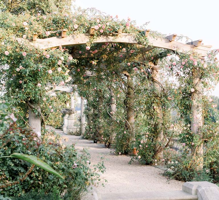 Beautiful pergola covered in green foliage and florals 