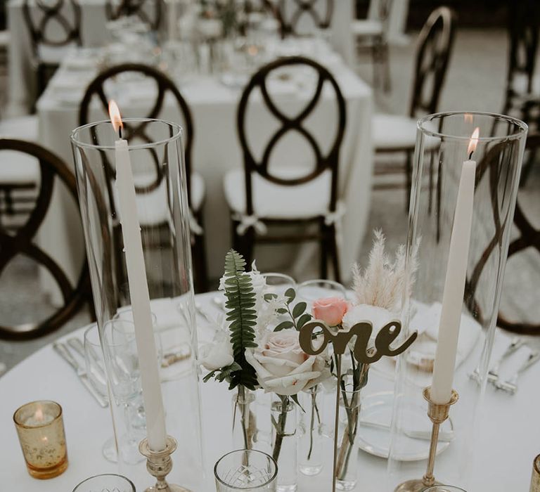 Clear glass and gold candle holders for tea lights with larger gold candleholders, white candles and pink and white roses